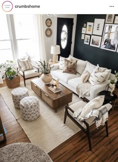 a living room filled with lots of furniture and pictures on the wall above it's windows