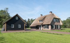 a large black house with a thatched roof