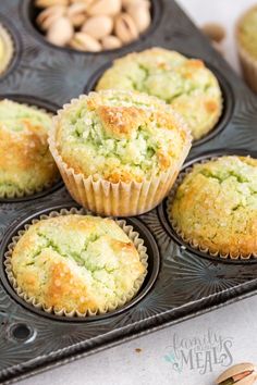 several muffins in a tray with nuts on the side