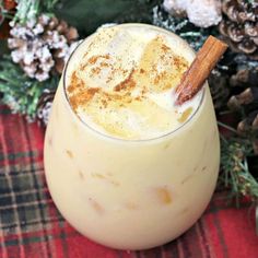 a close up of a drink in a glass with a cinnamon stick sticking out of it