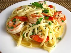 a white plate topped with pasta and shrimp