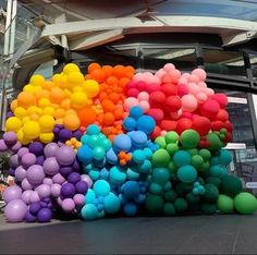 a large number of balloons in front of a building