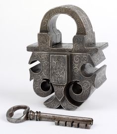 an old metal lock with two keys attached to it and the caption german padlock and key about 40 years old