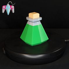 a green and white object sitting on top of a black surface next to a pair of scissors