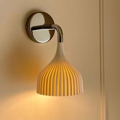 a wall light that is on the side of a wall next to a lamp shade