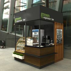 an outdoor coffee shop with wood accents and black counter top, on the sidewalk in front of a large glass building