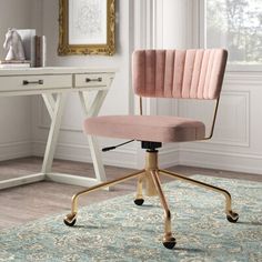 a pink office chair sitting on top of a rug in front of a white desk