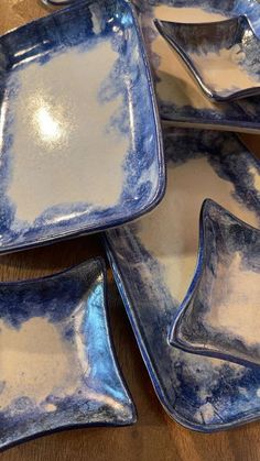 blue and white dishes on a wooden table with one empty plate in the middle,