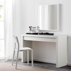 a white desk with a mirror and two stools