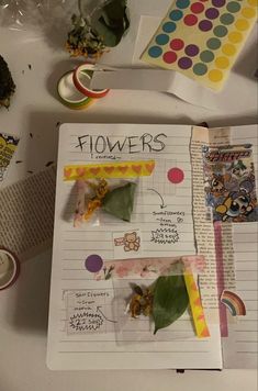 a book with flowers on it sitting next to other items and papers that include stickers