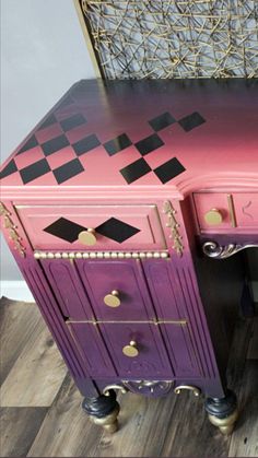 a pink and purple desk with gold hardware on it's legs, sitting in front of a mirror