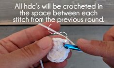 someone crocheting the end of a piece of white yarn with a blue needle