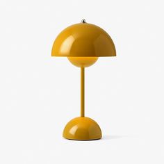 a yellow table lamp sitting on top of a white floor