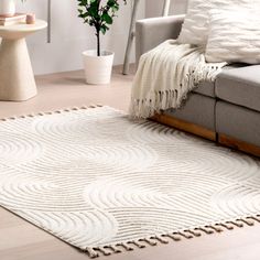 a living room with a gray couch and white rug