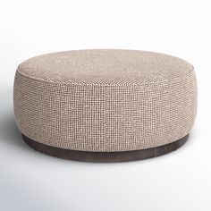 a round ottoman sitting on top of a white floor