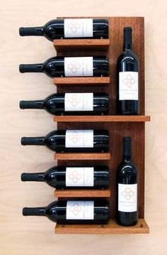 several bottles of wine are lined up in a wooden rack on the wall next to each other