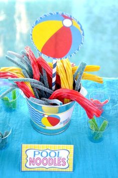 a pool noodle centerpiece in a bucket on top of a table with other items