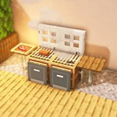 a small stove top oven sitting on top of a wooden table next to a potted plant