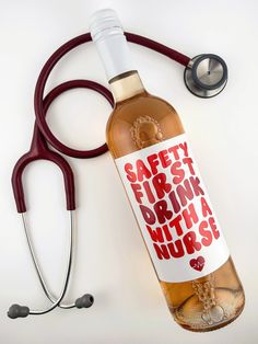 a bottle of alcohol next to a stethoscope on a white surface with the words safety first drink with a nurse's stethos