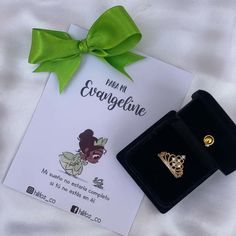 an earring with a green bow on it next to a card