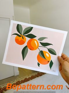 a person holding up a card with oranges on it