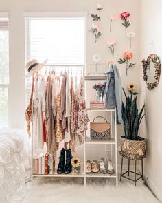 a white room with clothes and flowers on the wall