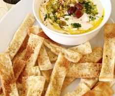 a white plate topped with crackers and a bowl of dip