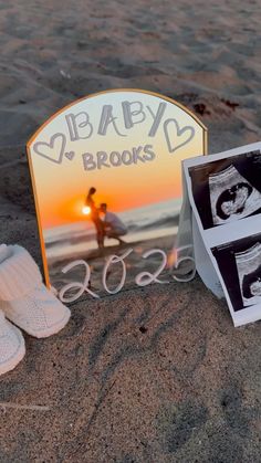 a baby's photo frame and slippers on the beach