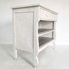 an old white wooden cabinet with drawers on one side and two shelves on the other