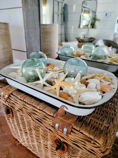 two wicker baskets filled with seashells and starfish on top of a table