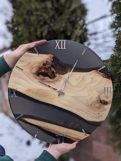 a person holding a clock made out of wood