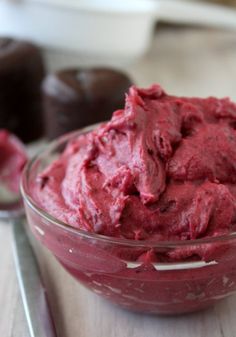 a glass bowl filled with red food on top of a wooden table