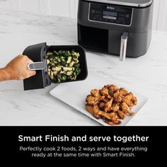 a person is holding a container with food in front of an air fryer on a counter