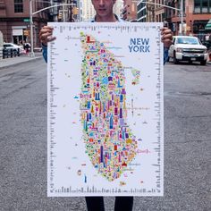 a man holding up a map of new york