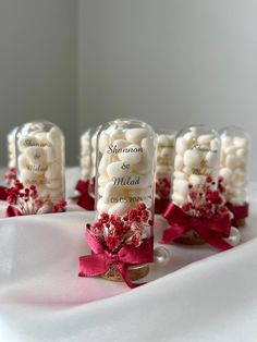 wedding favors in glass bottles with red bows