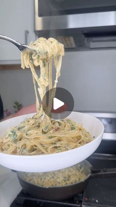 a spoon full of pasta being lifted from a bowl