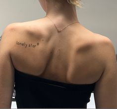 the back of a woman's shoulder with an inscription on it that reads lonely stop