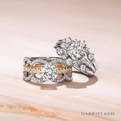 two wedding rings with diamond accents on top of each other in white and yellow gold