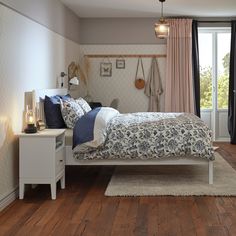 a bed room with a neatly made bed and wooden floors