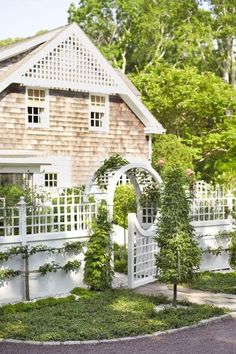 a house with a white fence and some bushes