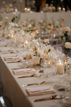 a long table is set with white flowers and candles for a formal dinner or reception