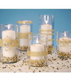 some candles are sitting on a table with gold sequins and beads around them