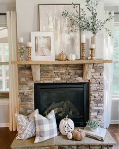 a living room filled with furniture and a fire place covered in pumpkins on top of a mantle