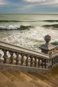 the stairs lead down to the beach where waves are crashing