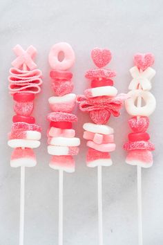 pink and white lollipops are arranged on top of each other in the shape of hearts