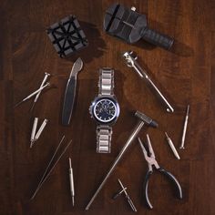 a watch surrounded by tools on a wooden table with an ad for swiss army watches