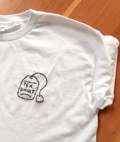 a white t - shirt with a tea bag drawn on it