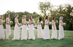 a group of women standing next to each other on top of a lush green field