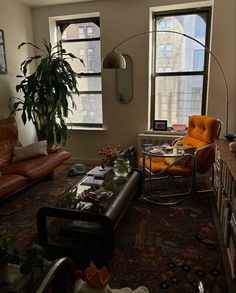 a living room filled with lots of furniture next to two large windows on the wall