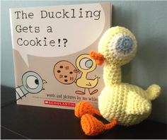 a crocheted stuffed duck sitting next to a book about the ducks who gets a cookie